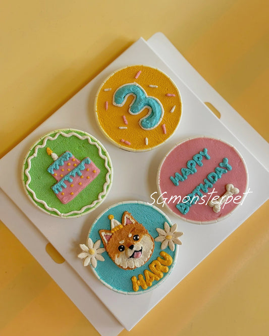 Four colorful cupcakes with decorative icing on a white tray against a yellow background.
