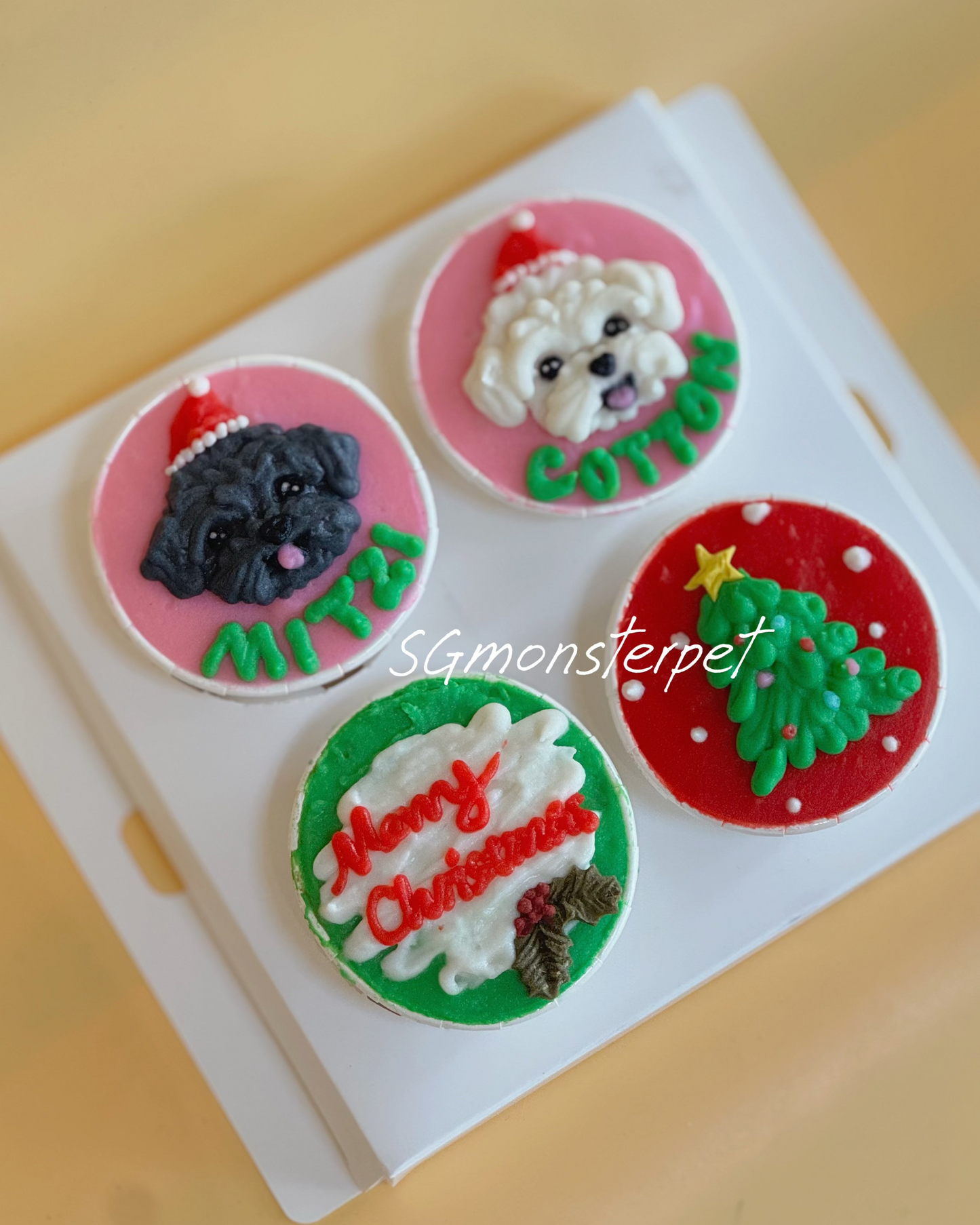 Four Christmas-themed dog cupcakes on a white box with 'SGMonsterpet' branding.