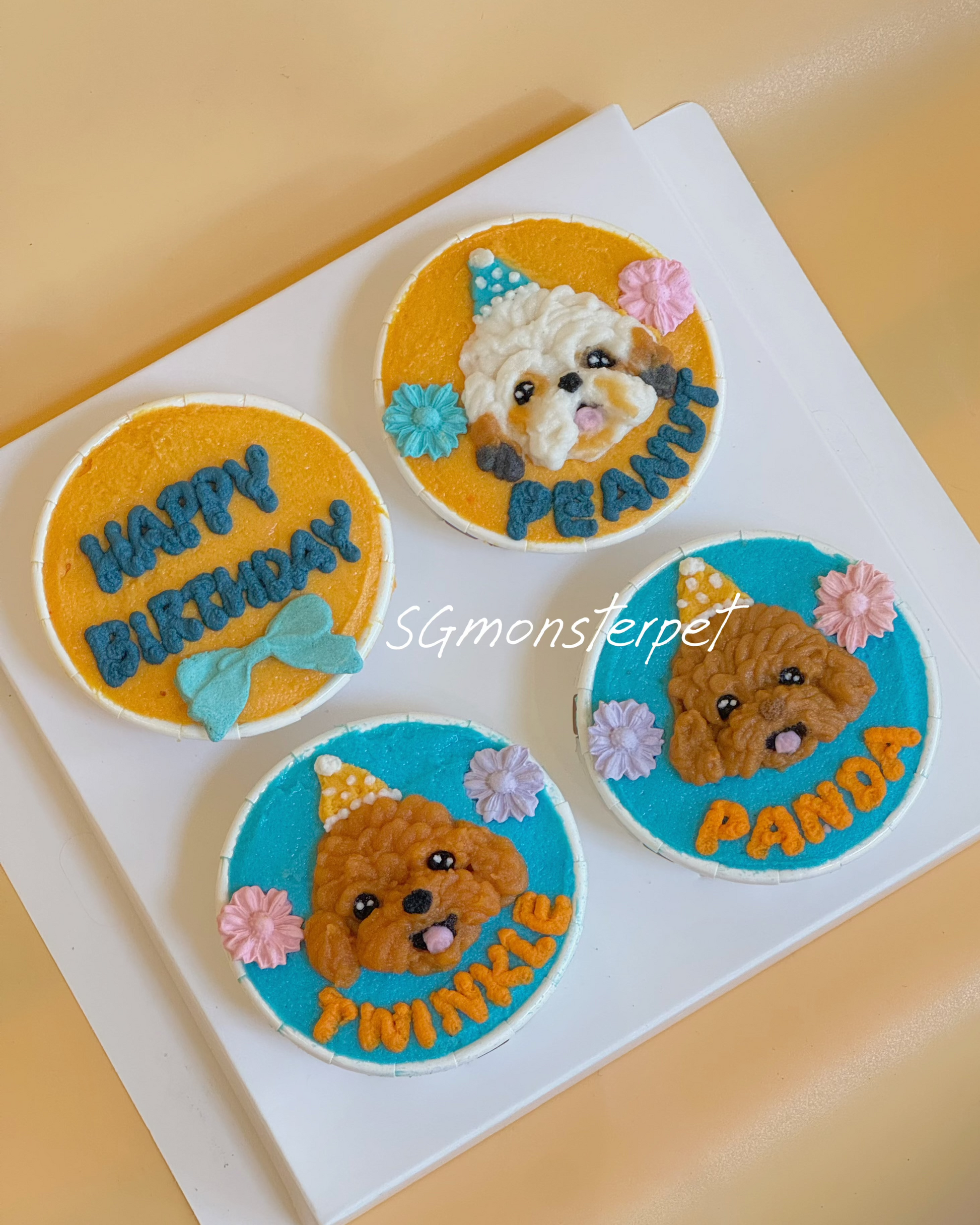 Four pet cupcakes with dog illustrations and names on a white tray.