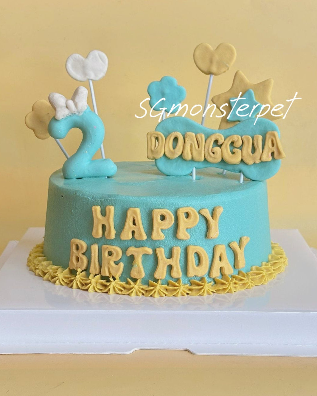 Blue birthday pet cake with gold lettering and decorations