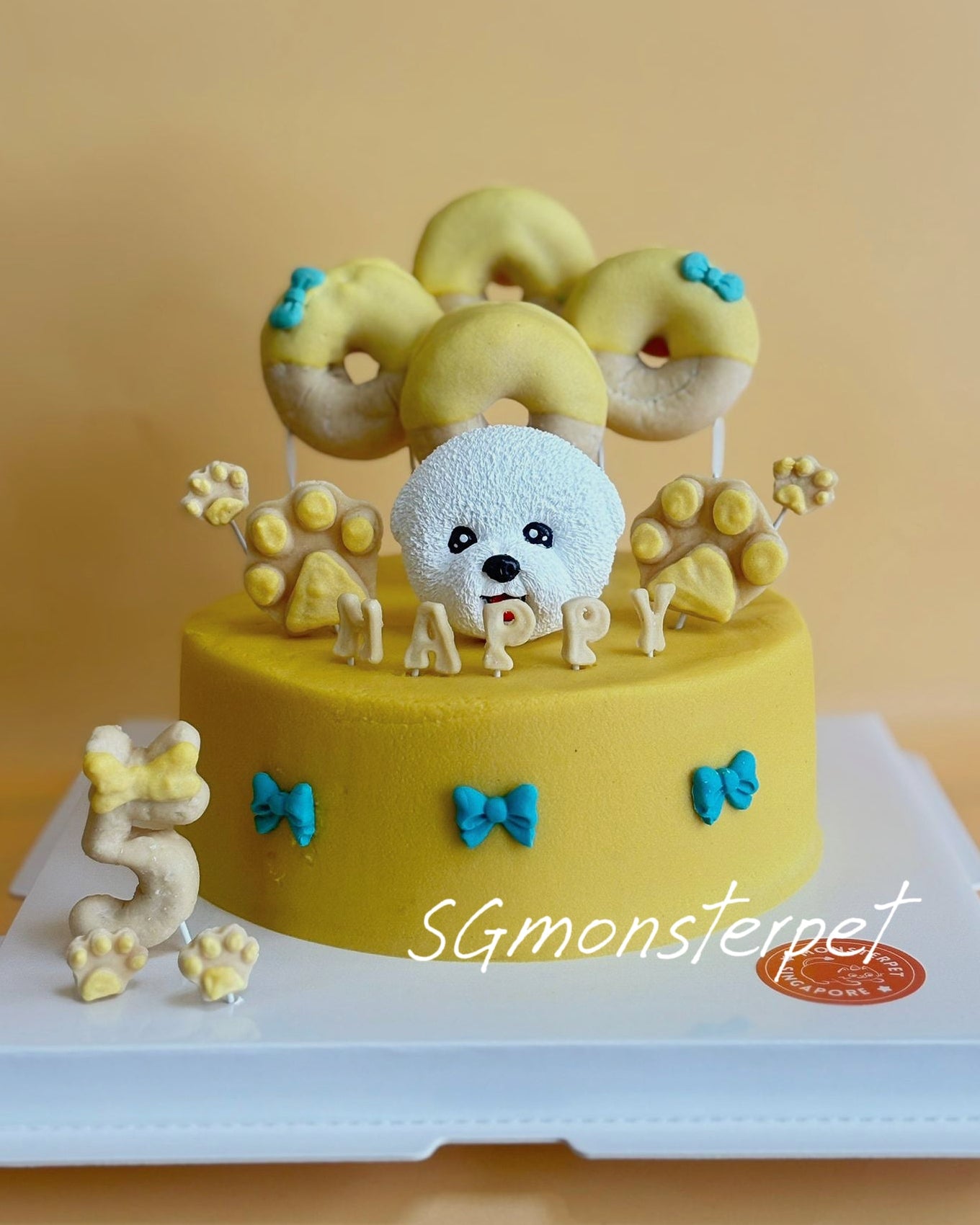 Dog-themed birthday pet cake with donuts and a small dog figurine.