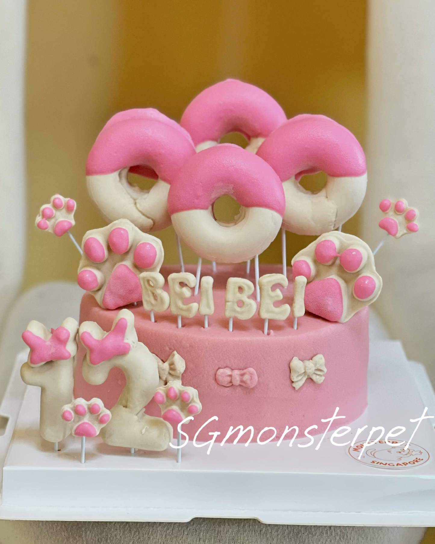 Pink and white dog-themed birthday pet cake with decorative elements.