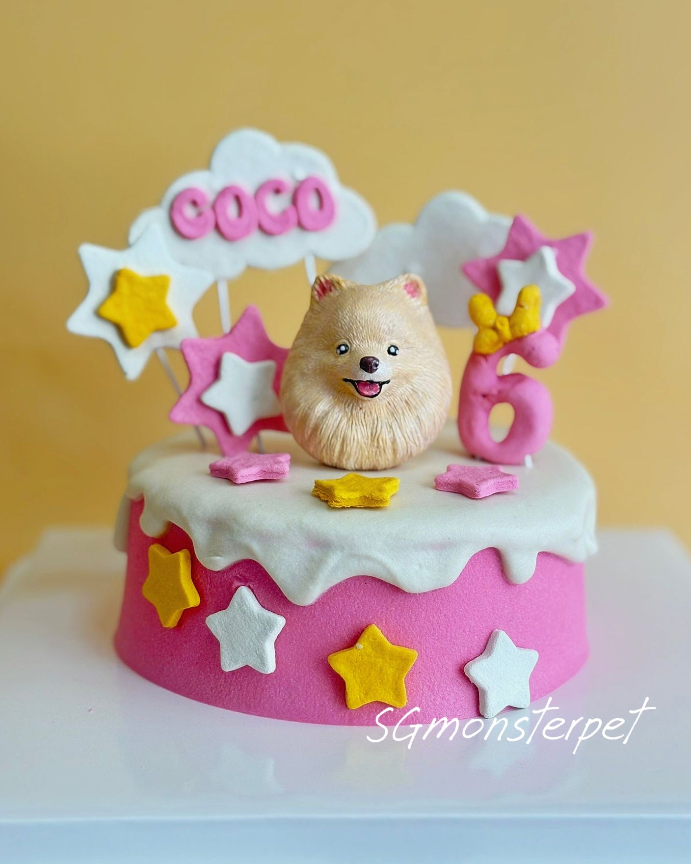 Pet birthday cake with a dog figurine and colorful decorations.