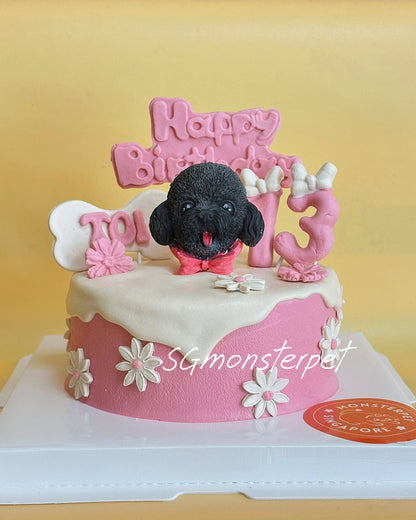 Pink birthday cake with a black dog figurine and 'Happy Birthday' topper on a yellow background.