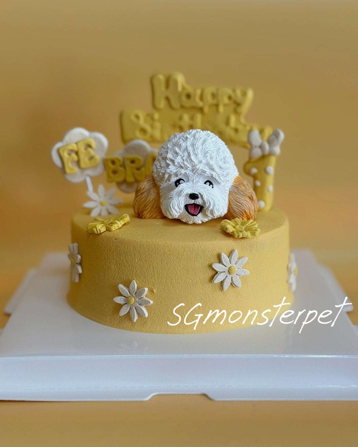 Yellow pet cake with a dog figurine and 'Happy Birthday' topper on a white stand.