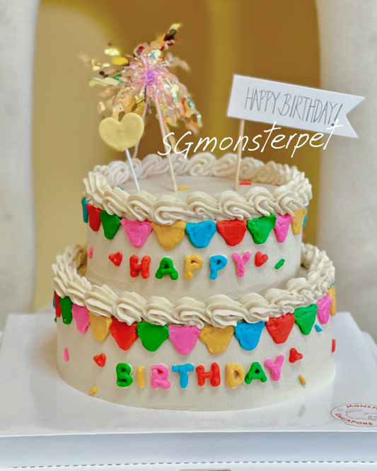 Two-tier birthday pet cake with colorful decorations and 'Happy Birthday' wording