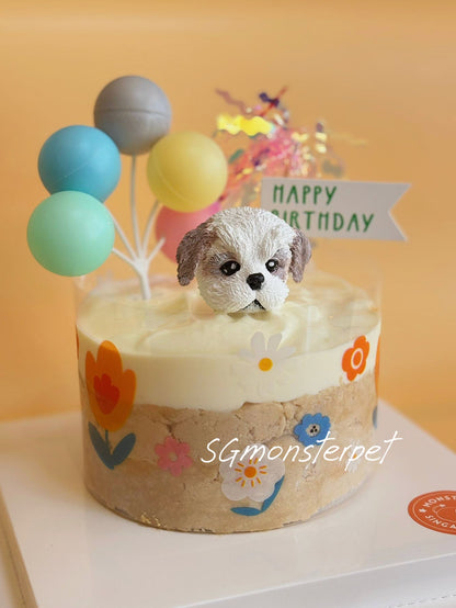 Small birthday pet cake with a dog figurine and colorful balloons on a white plate.
