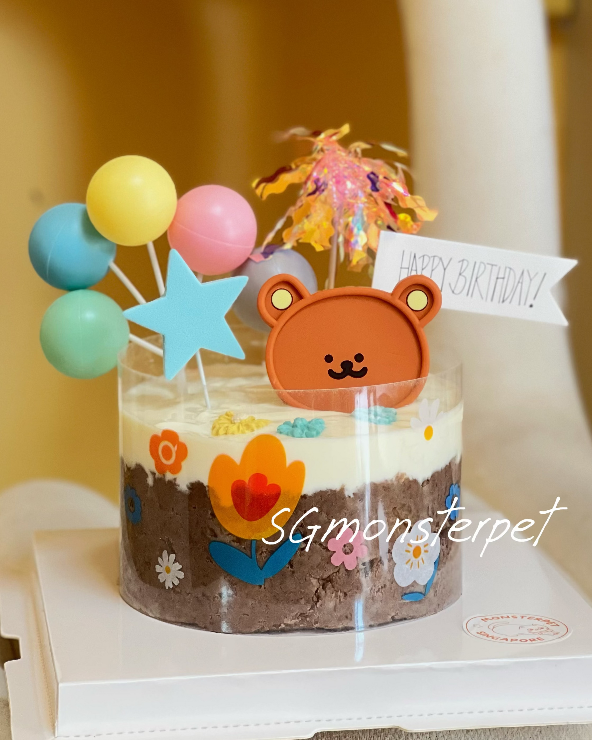 Small birthday pet cake with teddy bear decoration on a white chair