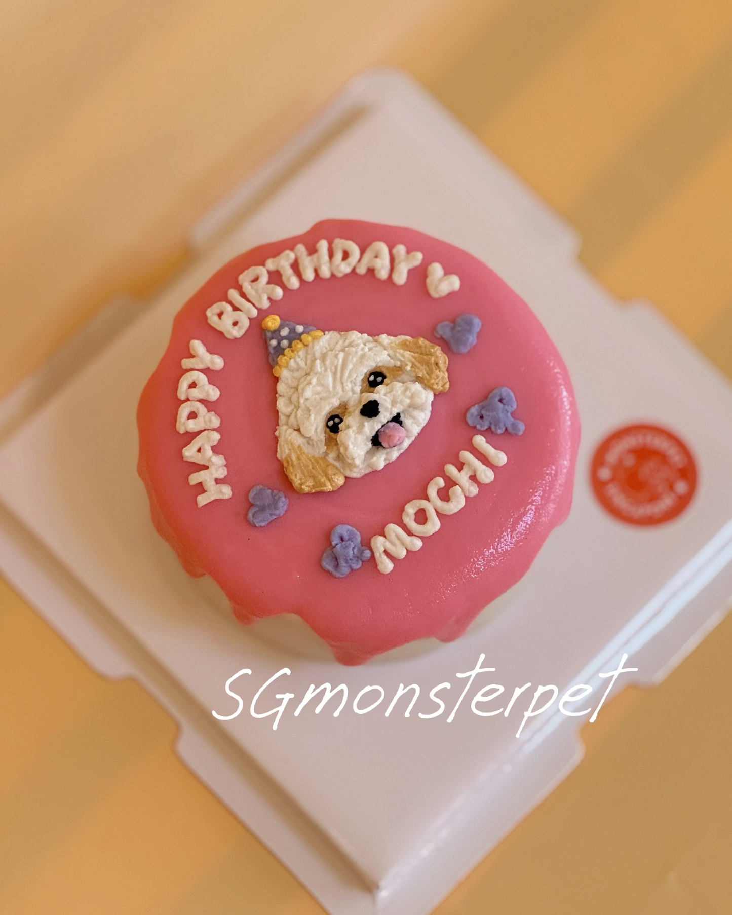 Pink birthday pet cake with a dog design and 'Happy Birthday' text on a yellow background.