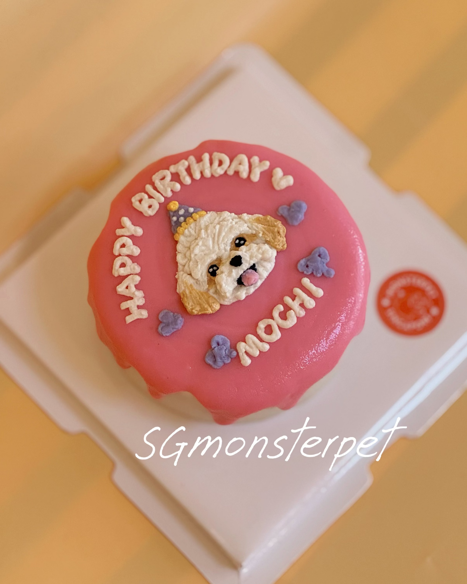 Pink birthday pet cake with a dog design and 'Happy Birthday' text on a yellow background.