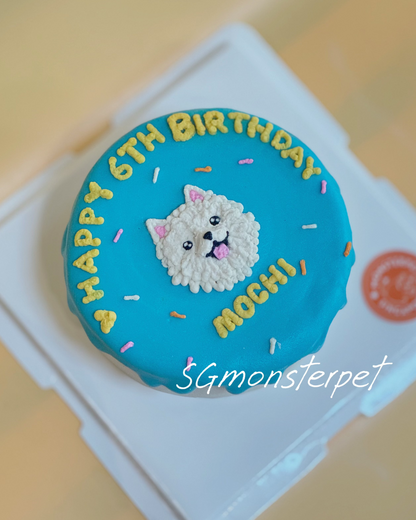 Small round blue birthday pet cake with a cat design and text on a white stand.