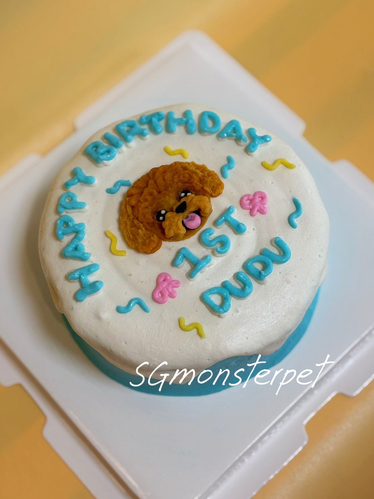 Small round birthday pet cake with a dog design and 'Happy Birthday' text on a yellow background.
