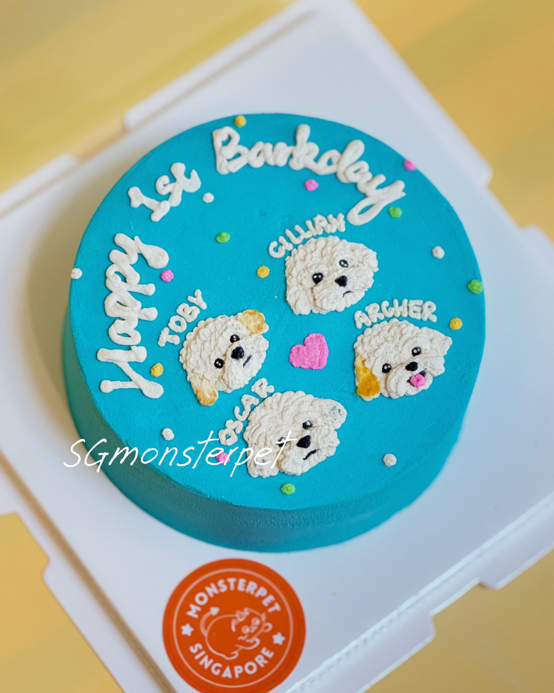 Round blue pet cake with dog-themed decorations and text, branded 'SGmonsterpet'.