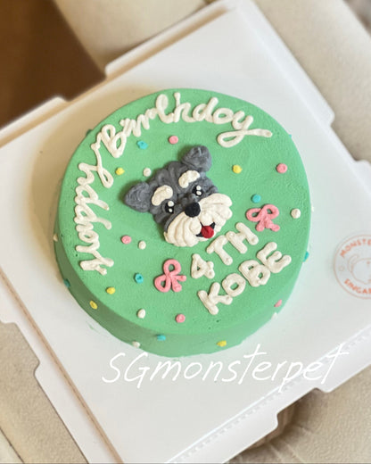 Green birthday pet cake with a dog design and text on a white box, placed on a beige surface.