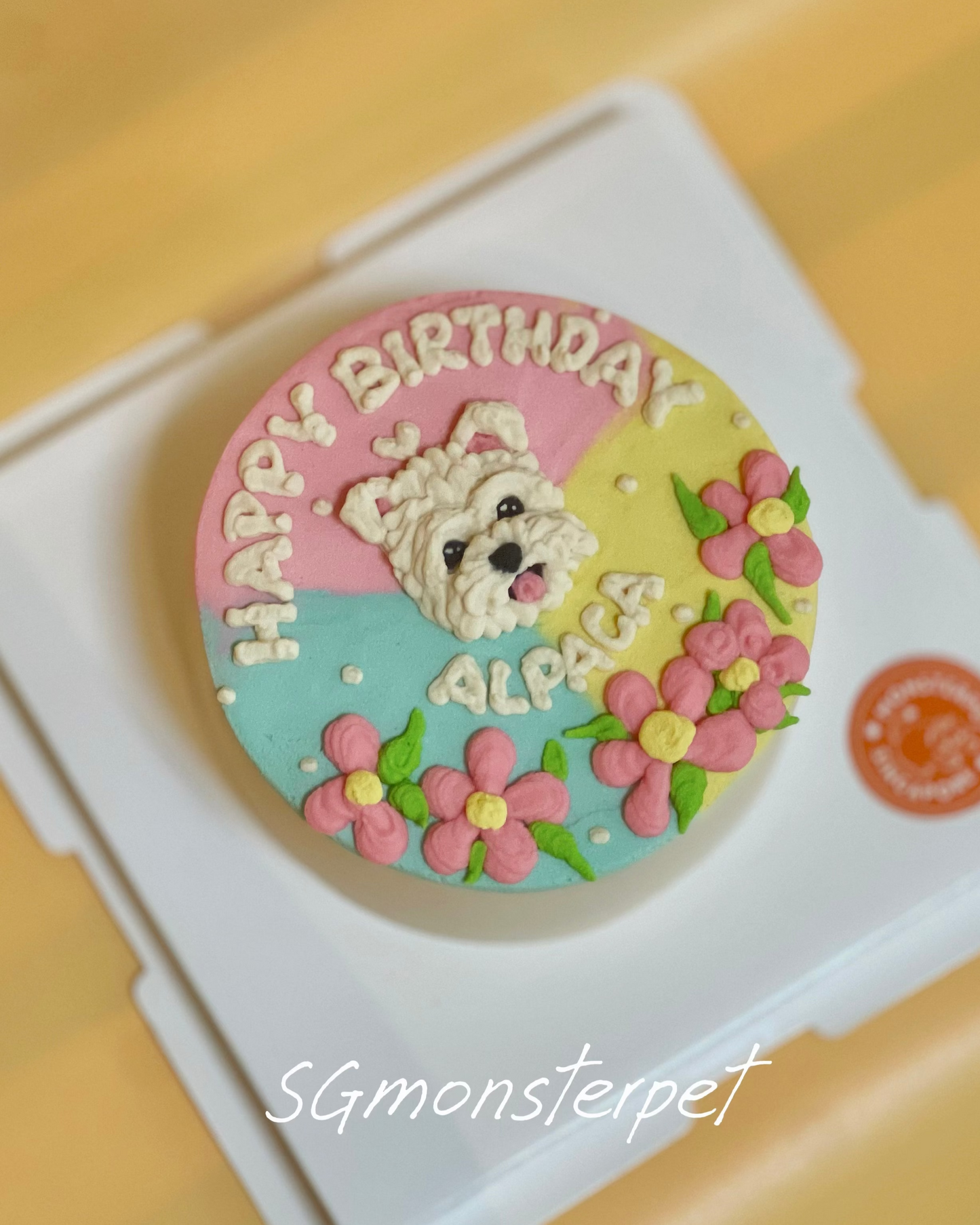 Round birthday oet cake with a dog design and 'Happy Birthday' text on a yellow surface.