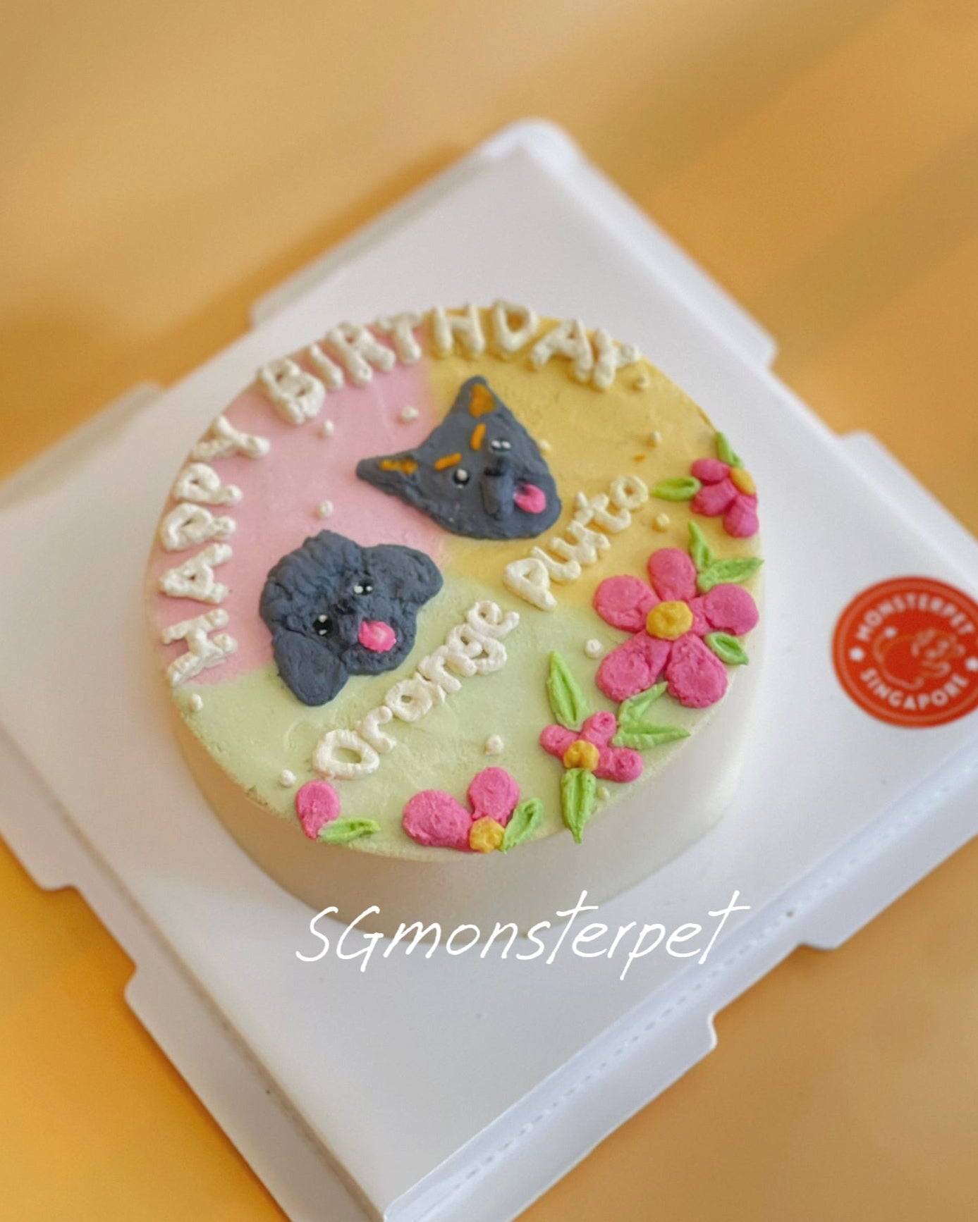 pet cake with cat designs and 'Happy Birthday' text, branded 'SGmonsterpet', on a yellow background.