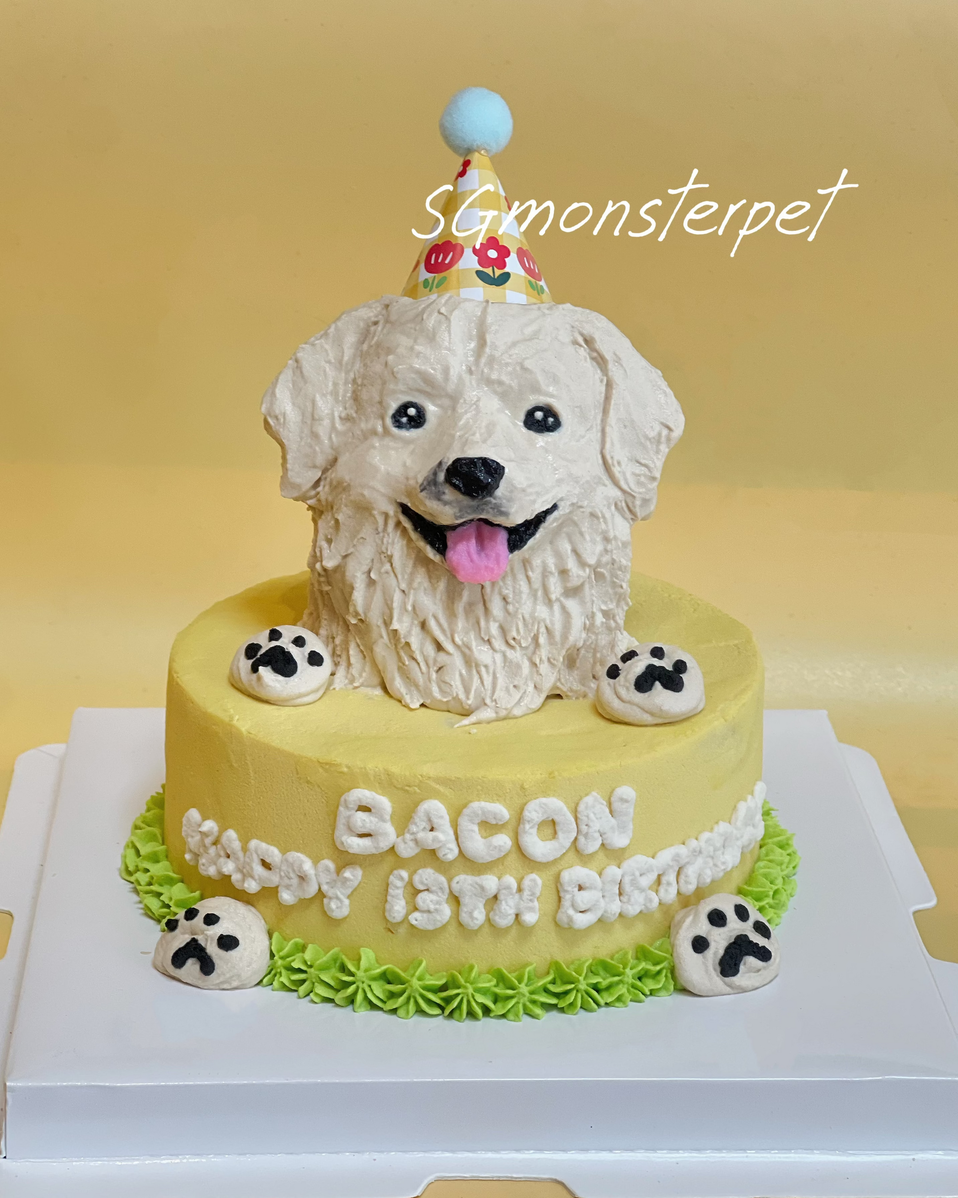 Dog-shaped birthday cake with a yellow base and white dog figure on a yellow background