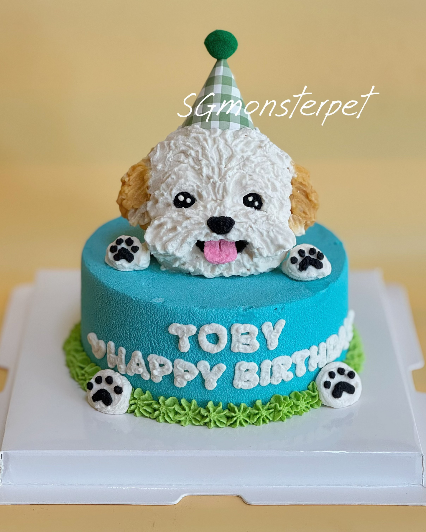 Birthday cake with a dog topper on a white stand, featuring the name and 'Happy Birthday' text.