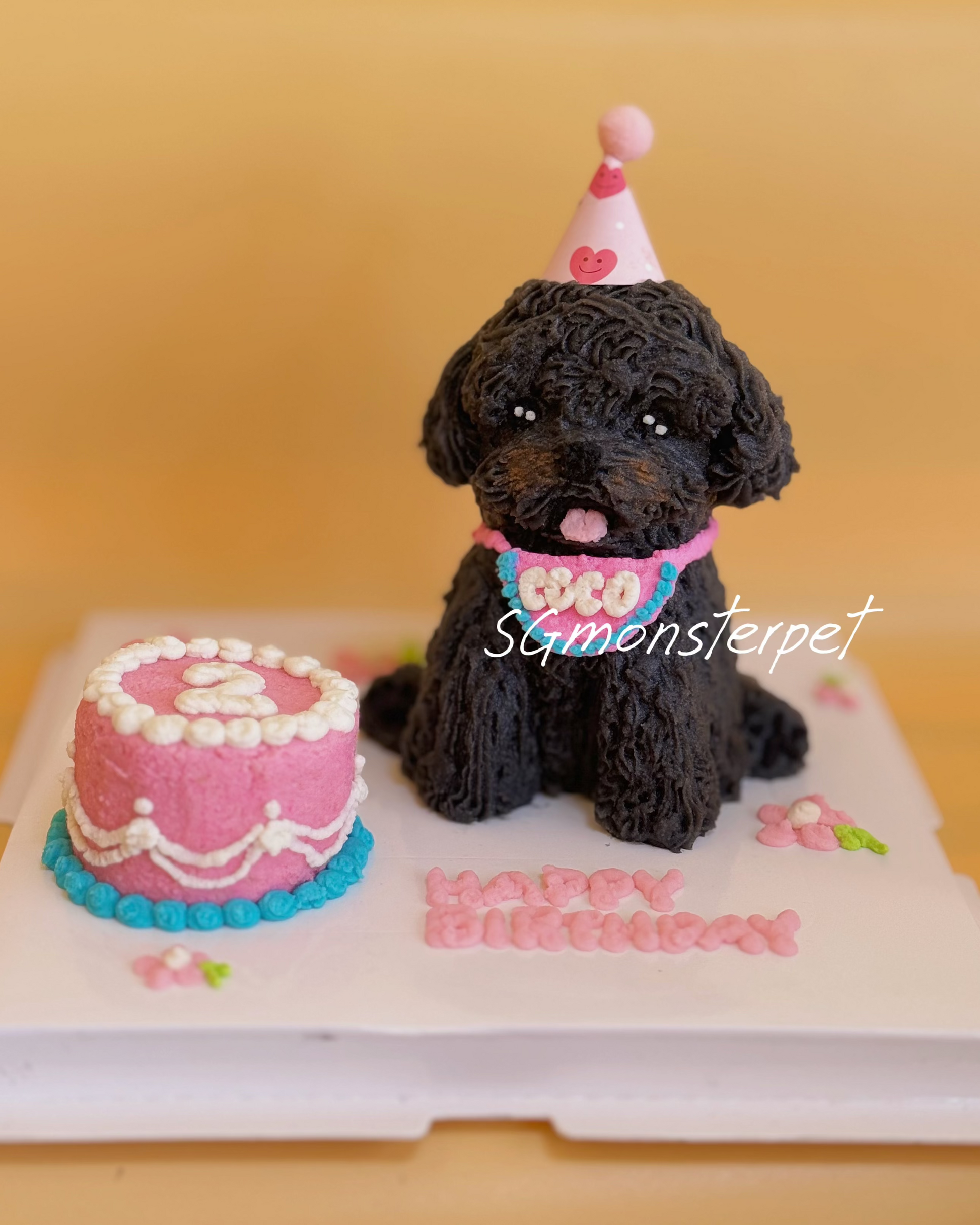 Dog-shaped birthday cake with a pink cake and 'Happy Birthday' text on a yellow background.