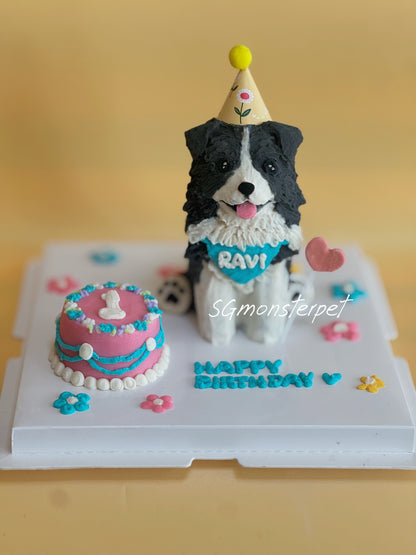 Dog-shaped birthday cake with a small cake and 'Happy Birthday' text on a white surface.