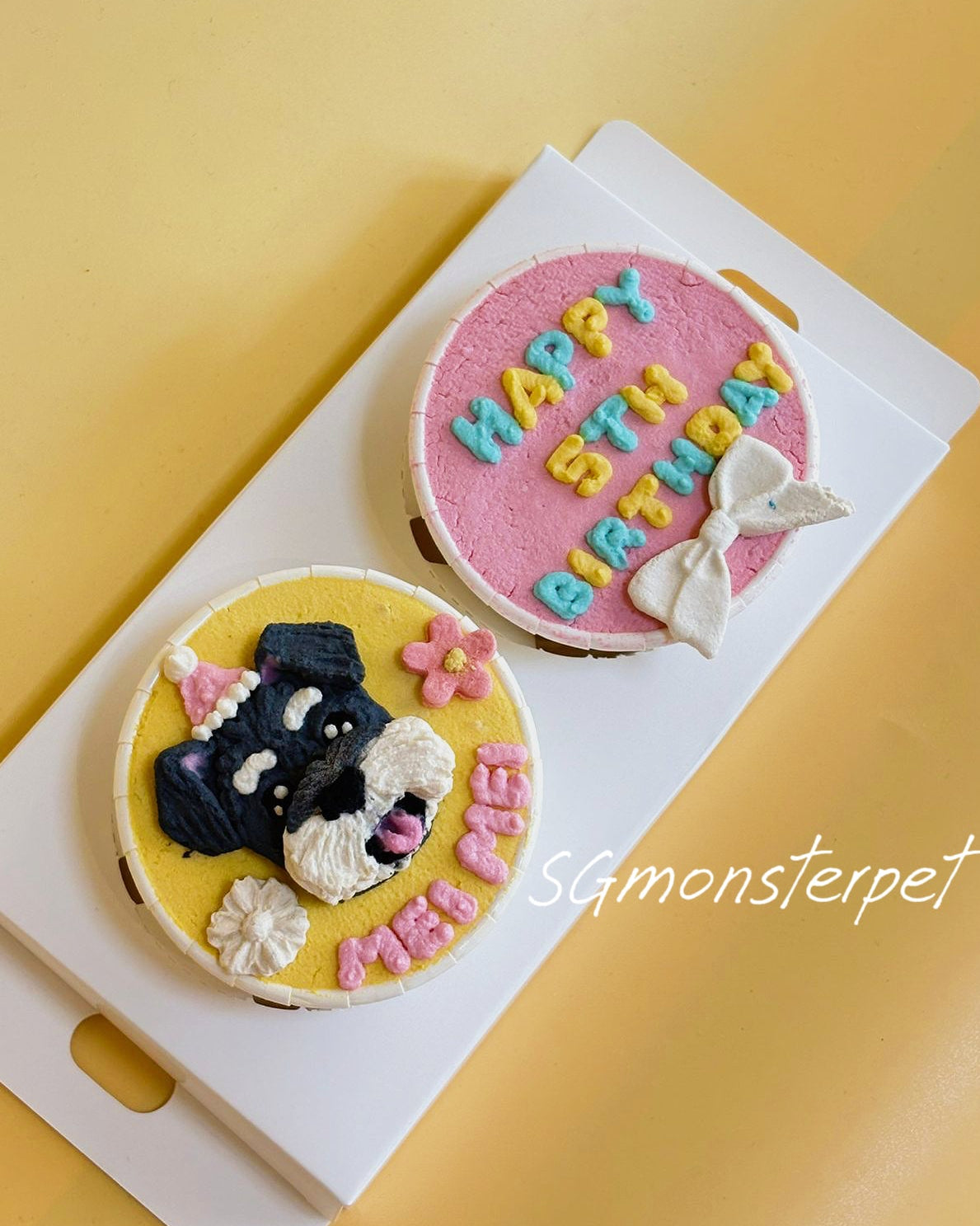 Two decorative cupcakes with a cat design and 'Happy Birthday' text on a yellow background.