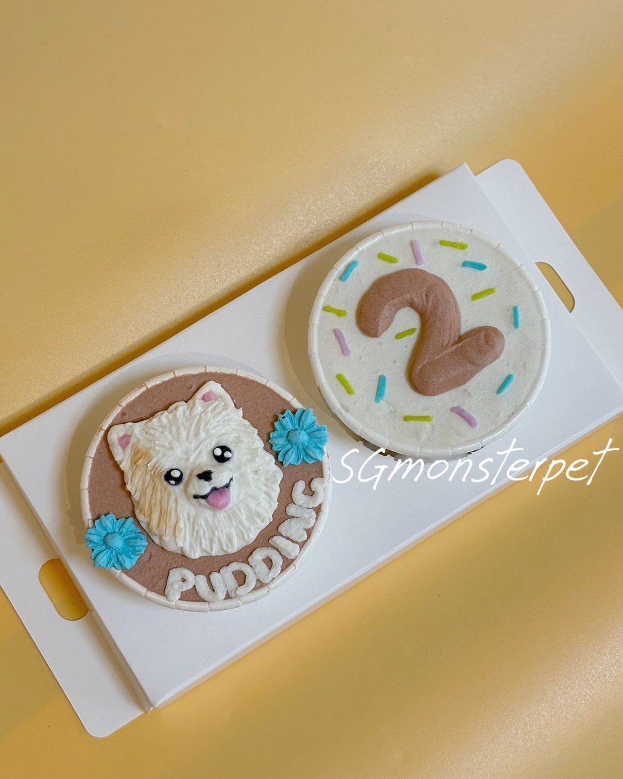 Two dog-themed cookies with a number 2 and 'Pudding' text on a yellow background.
