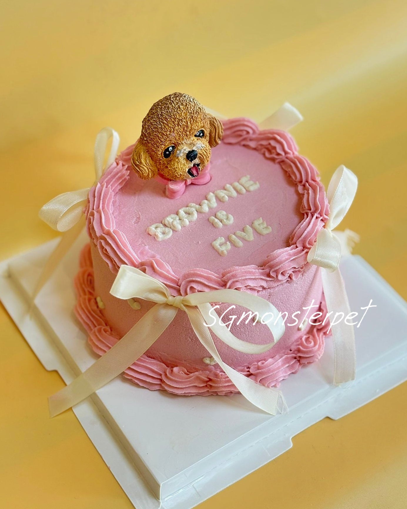 Pink birthday pet cake with a dog figurine on top